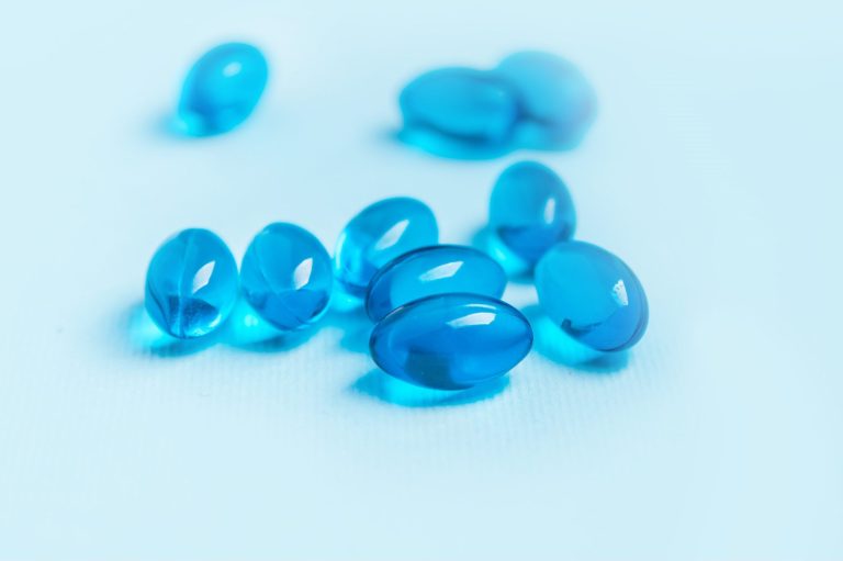 Single blue softgel capsule pill isolated